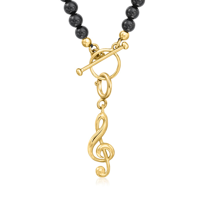 Gold treble clef charm hanging from black beaded necklace