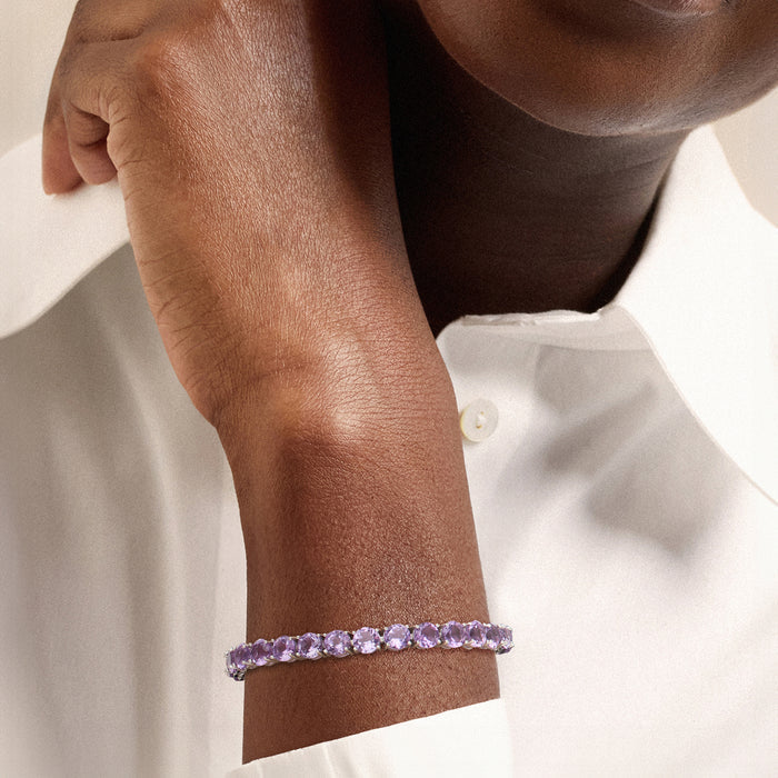 Sterling silver amethyst tennis bracelet on wrist with purple oval stones