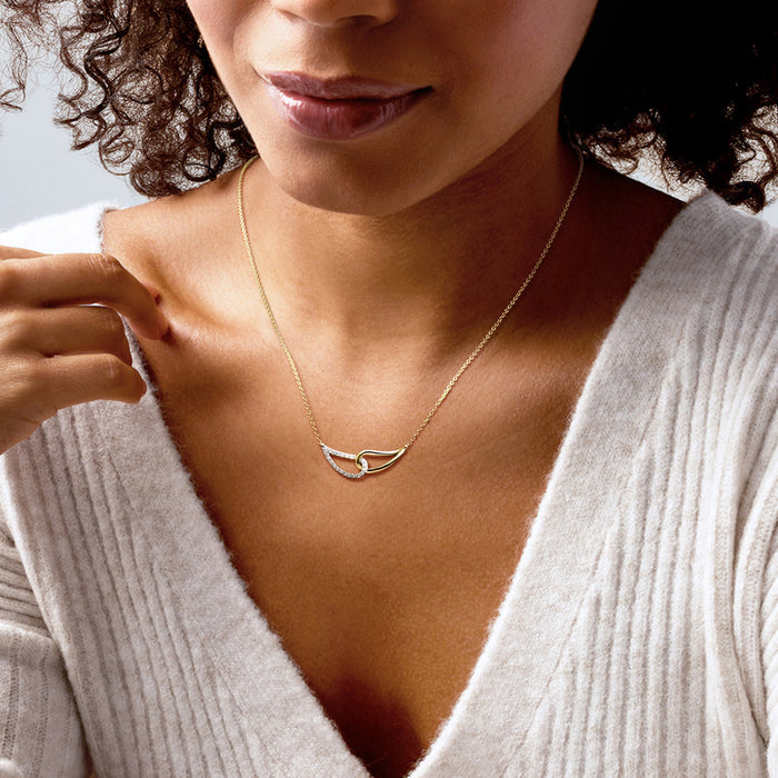 Gold-toned interlocking loop diamond necklace with short chain worn at collar