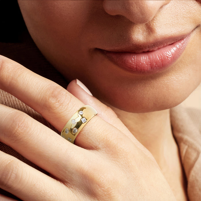 Gold lab-grown diamond ring with mixed round and square stones on finger