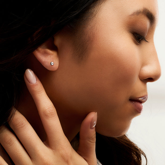 4mm platinum ball stud earrings on ear with small round polished balls