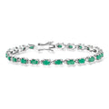 Sterling silver tennis bracelet with green oval emeralds and small clear diamonds
