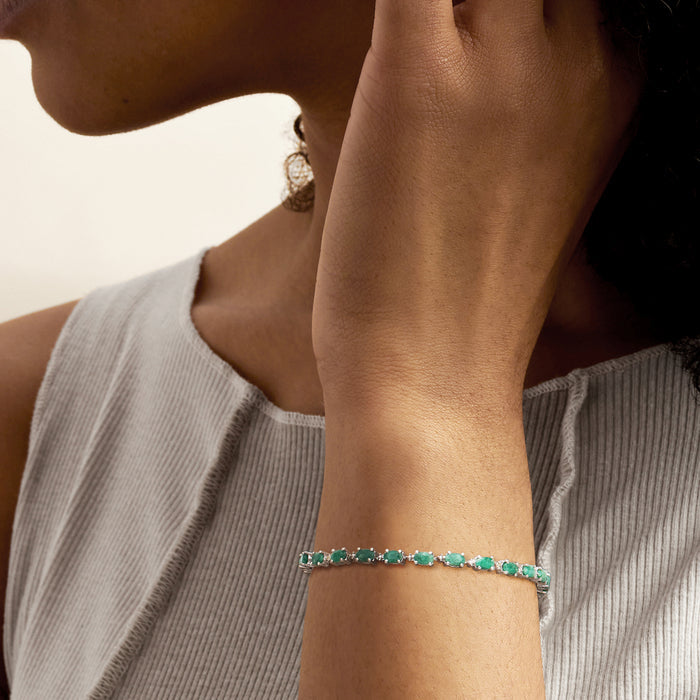 Sterling silver bracelet with green oval emeralds, worn on wrist