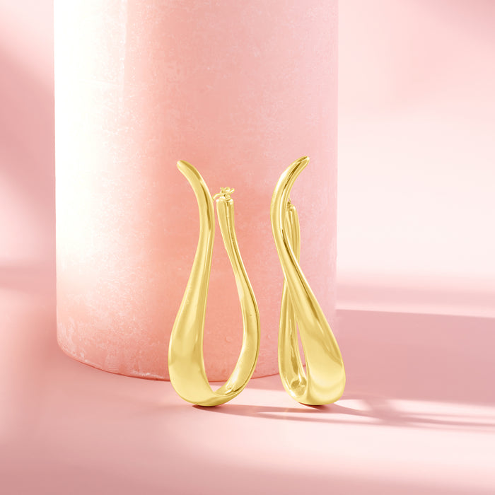 Twisted gold hoop earrings with hinged closure, glossy teardrop loop shape