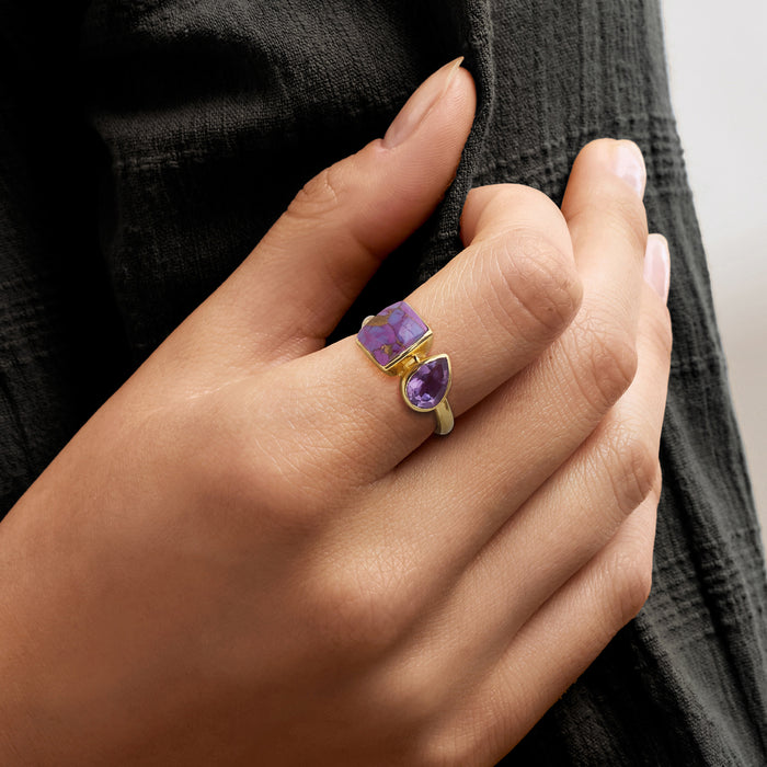 Gold toi et moi ring worn on hand with square purple-and-blue stone and purple pear gem