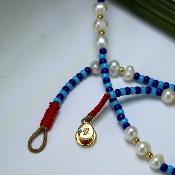 Roxanne Assoulin Necklace Blue Beads Pearls Classic Button Fastener Logo closeup and logo RA
