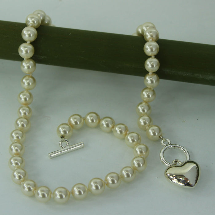 Single Strand Faux Pearl Necklace Silver Heart Bar Closure  table view of necklace
