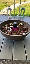 Terracotta Plastic Garden Planter with brown and gold glass stones and a small black fountain on a gray table, lanterns, and green lawn.